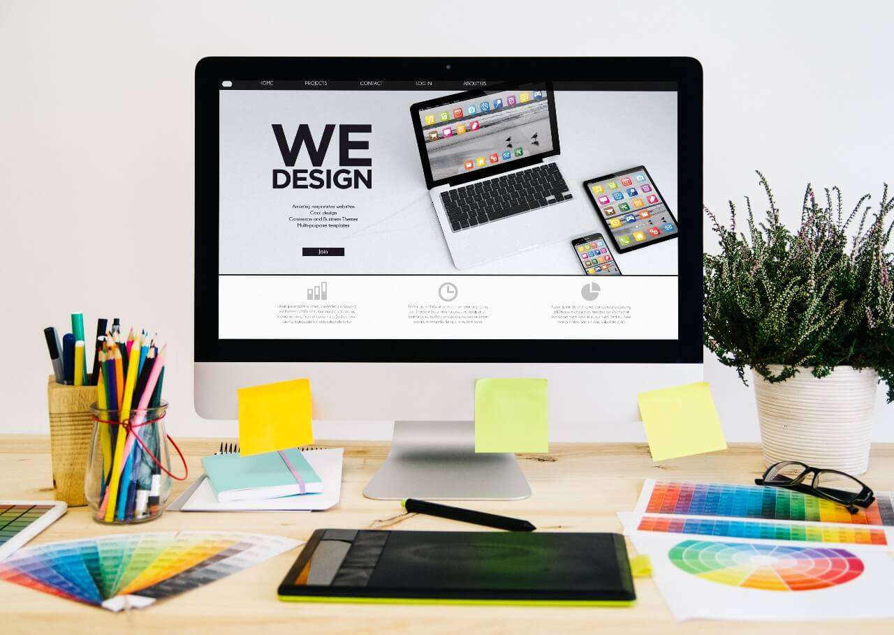 Kreativt skrivebord med skjerm og fargeblyanter – symbol for visuell identitet og design